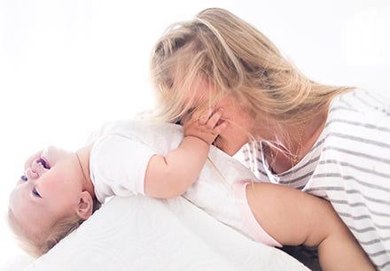 Mother and baby playing wearing Burt's Bees Baby onesie