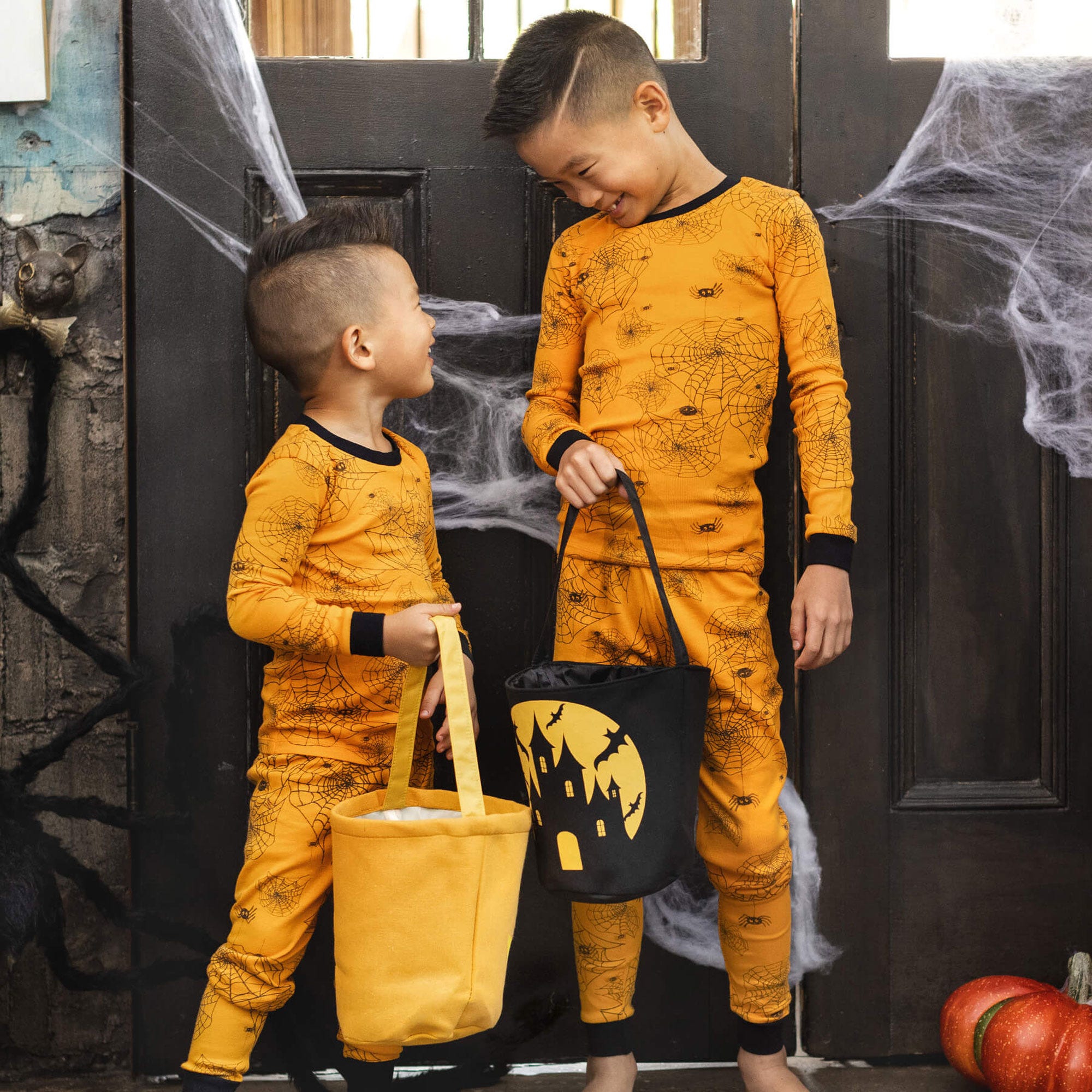Toddler boys wearing matching organic cotton Halloween pajamas by Burt's Bees Baby